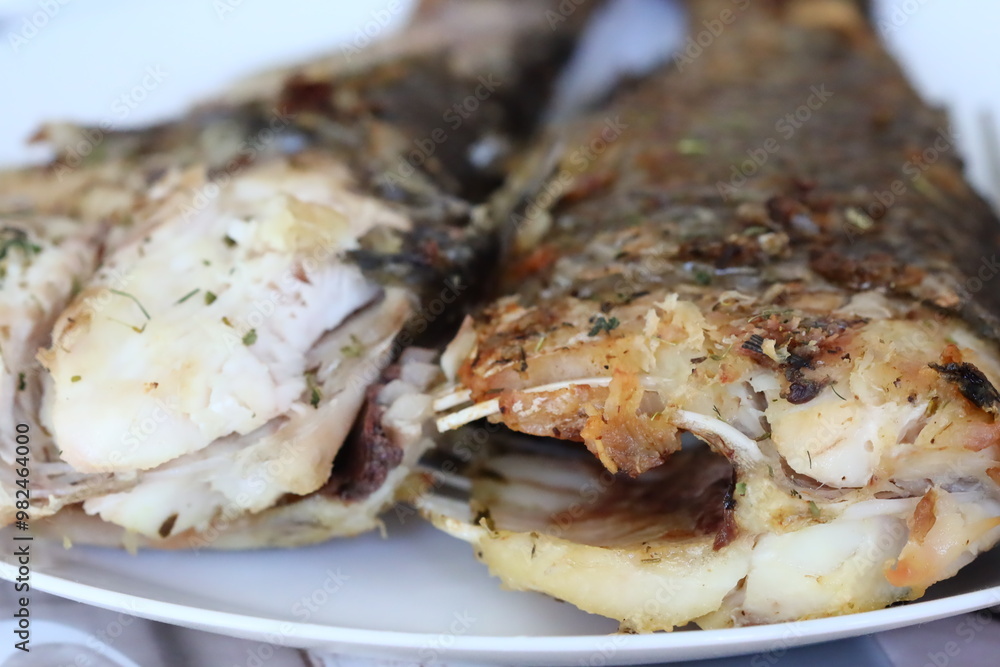 A plate filled with fish smothered in savory sauce, perfect for a meal or dinner occasion A plate filled with fish smothered in savory sauce, perfect for a meal or dinner occasion