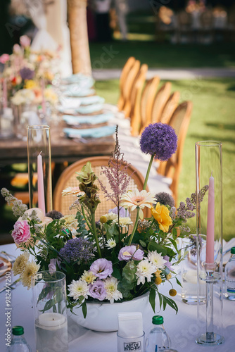 Obraz na płótnie Outdoor Wedding Reception with Brown Chairs and Decorated Tables on a Green Lawn in a Scenic Nature Setting w salonie