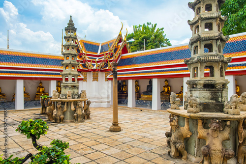 Entrance to Wat Pho Temple Complex with traditional statues, golden Buddha figures, pagodas and vibrant roof architecture in courtyard, Bangkok city, Thailand, Asia. Temple of the Reclining Buddha photo