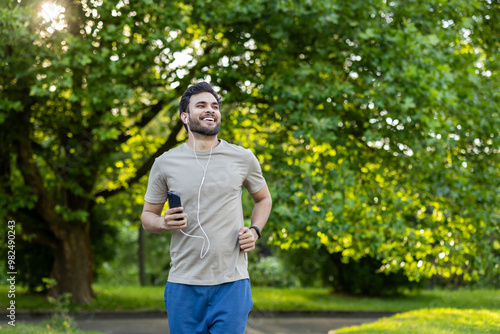 Canvastavla Active man jogging in lush green park with phone and headphones enjoying fitness