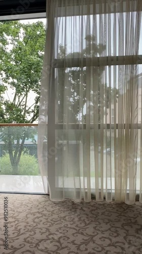 Window with curtain blowing in the wind