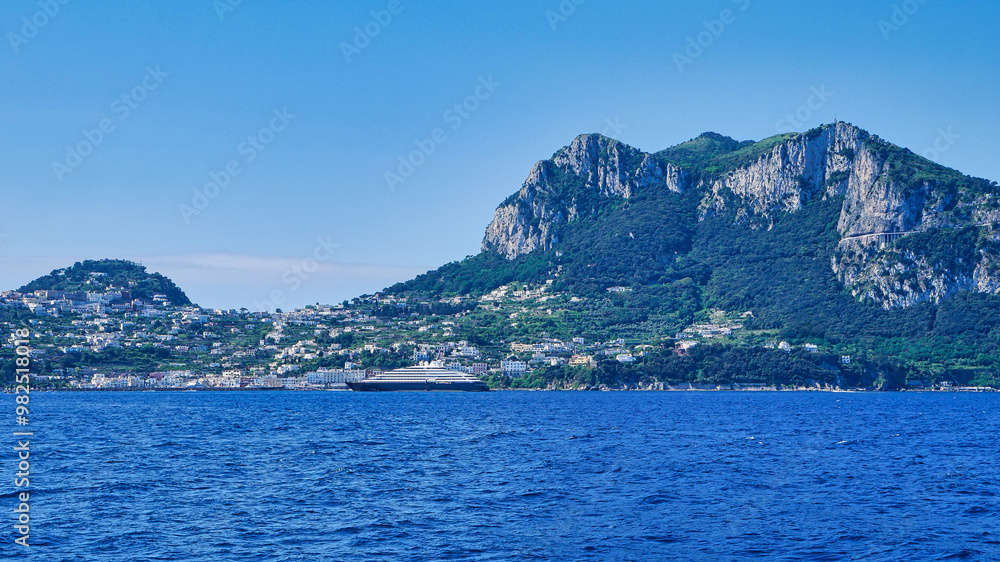 Eine Luxusyacht im Hafen von Capri mit Bergkulisse im Hintergrund Eine Luxusyacht im Hafen von Capri mit Bergkulisse im Hintergrund