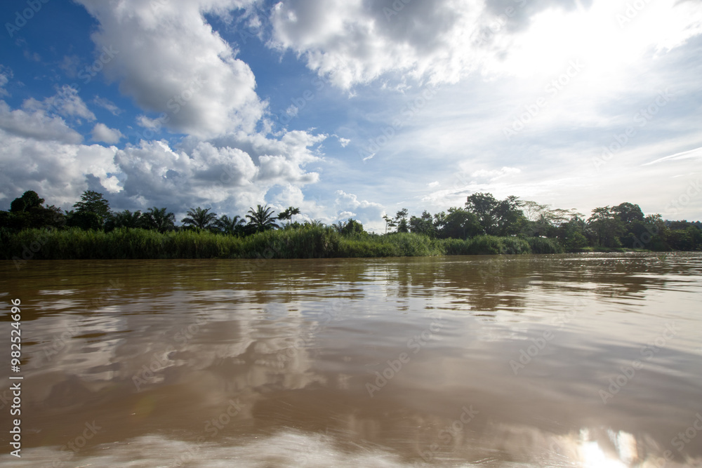 A tranquil river scene under a bright sky, reflecting clouds and surrounded by lush greenery, showcasing the beauty of nature's waterways. A tranquil river scene under a bright sky, reflecting clouds and surrounded by lush greenery, showcasing the beauty of nature's waterways.
