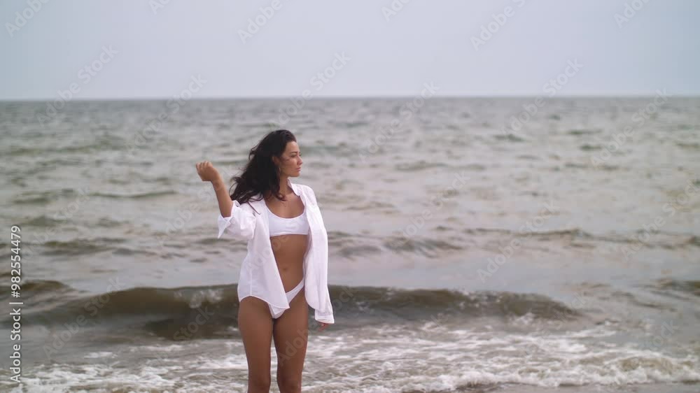 Pensive Woman in White Bikini Facing Stormy Sea Pensive Woman in White Bikini Facing Stormy Sea