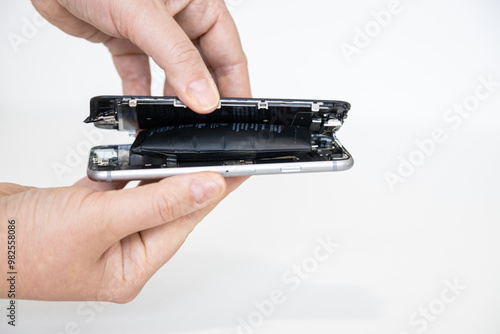 Hand holding a phone with a swollen battery against a white background
