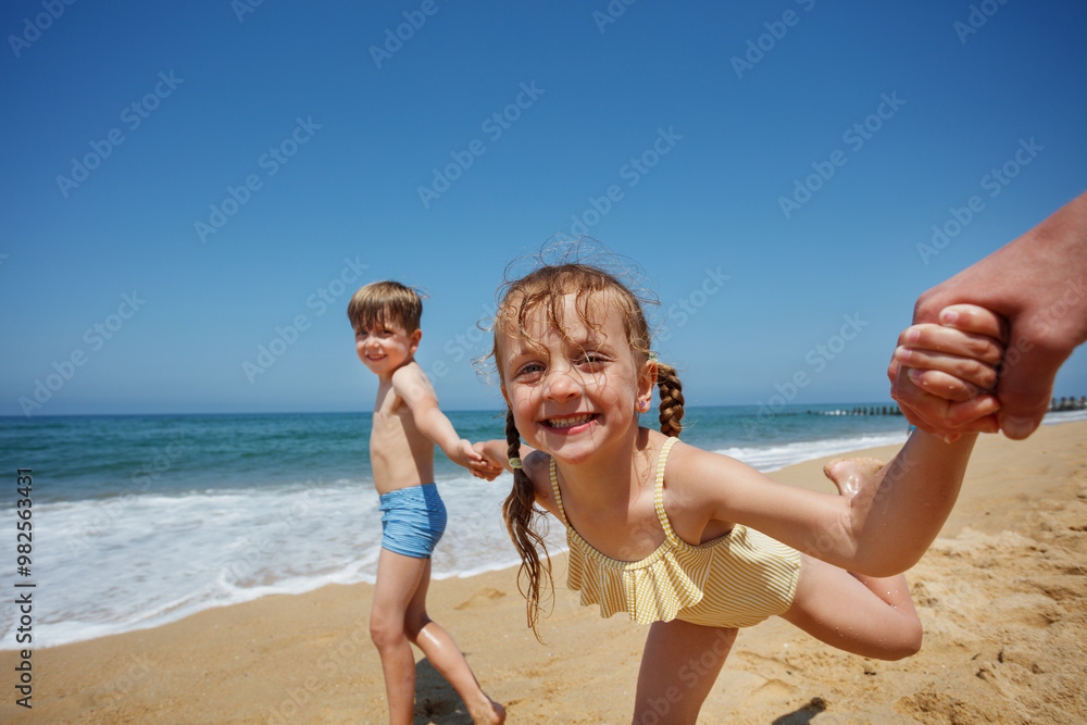 Children boy and girl laugh, hold hands on a sunny beach day Children boy and girl laugh, hold hands on a sunny beach day