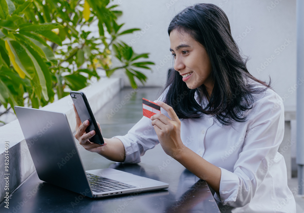 Beautiful young asian woman holding credit card and using laptop computer. Online shopping concept. Beautiful young asian woman holding credit card and using laptop computer. Online shopping concept.