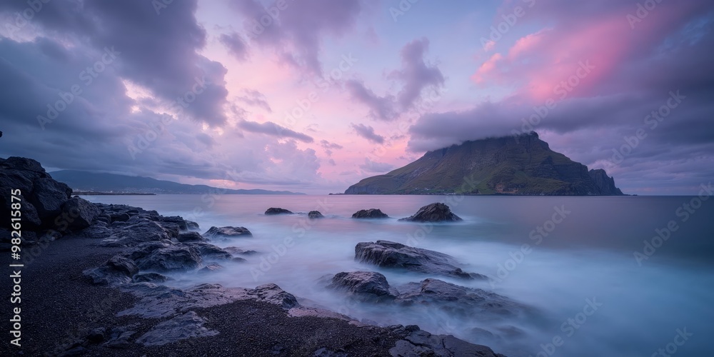 Serene coastal landscape with a mountain under a pink and purple sunset sky. Serene coastal landscape with a mountain under a pink and purple sunset sky.