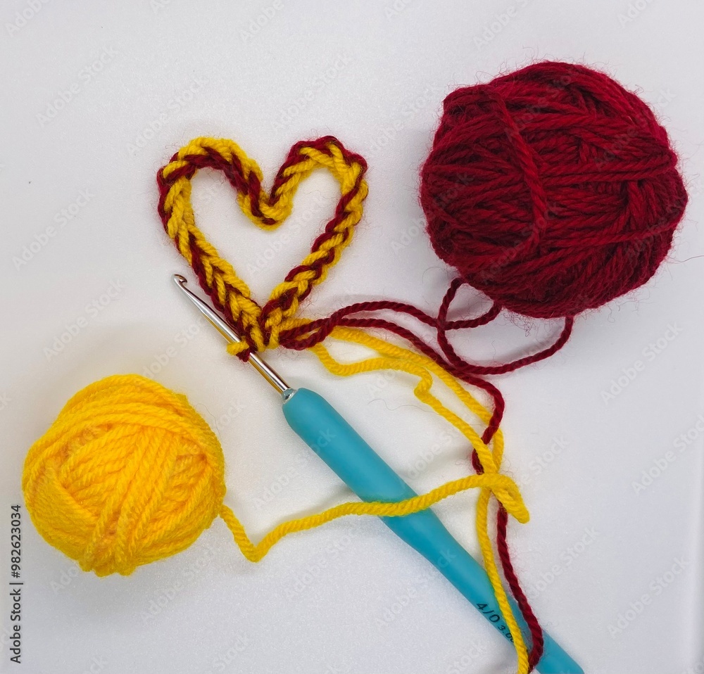 The heart knitted from two different colors clews of wool The heart knitted from two different colors clews of wool