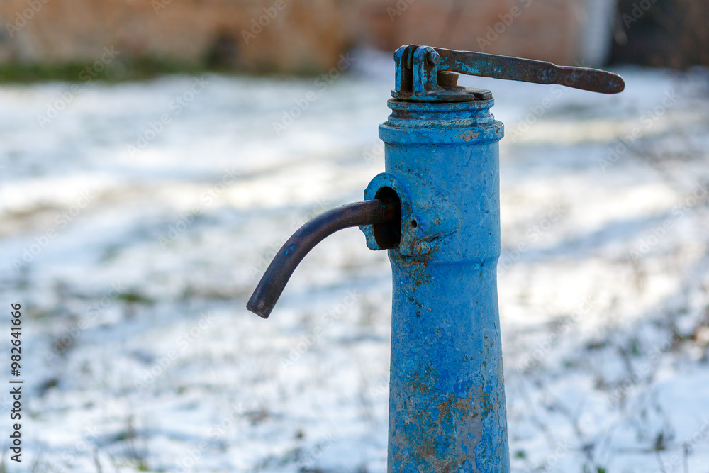 Obraz premium Enlarged plan of the drinking water column. Old water column with blue cracked paint.