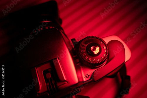 Vintage camera with lens in red light environment. Photography concept and copy space photo