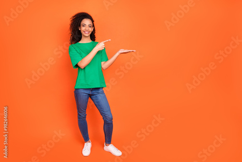 Photo of young attractive girl wearing green casual t shirt advertising it courses academy isolated on orange color background