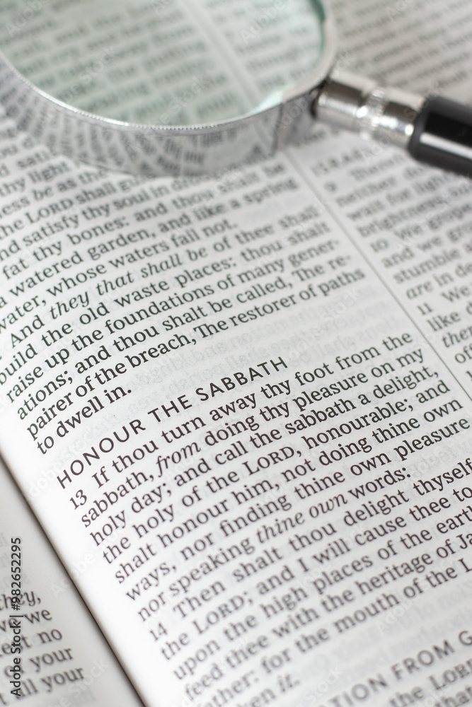 Obraz premium Honor the Sabbath verse in open holy bible book with magnifying glass. Christian biblical concept of seventh day rest, blessing, and obedience to God Jesus Christ.