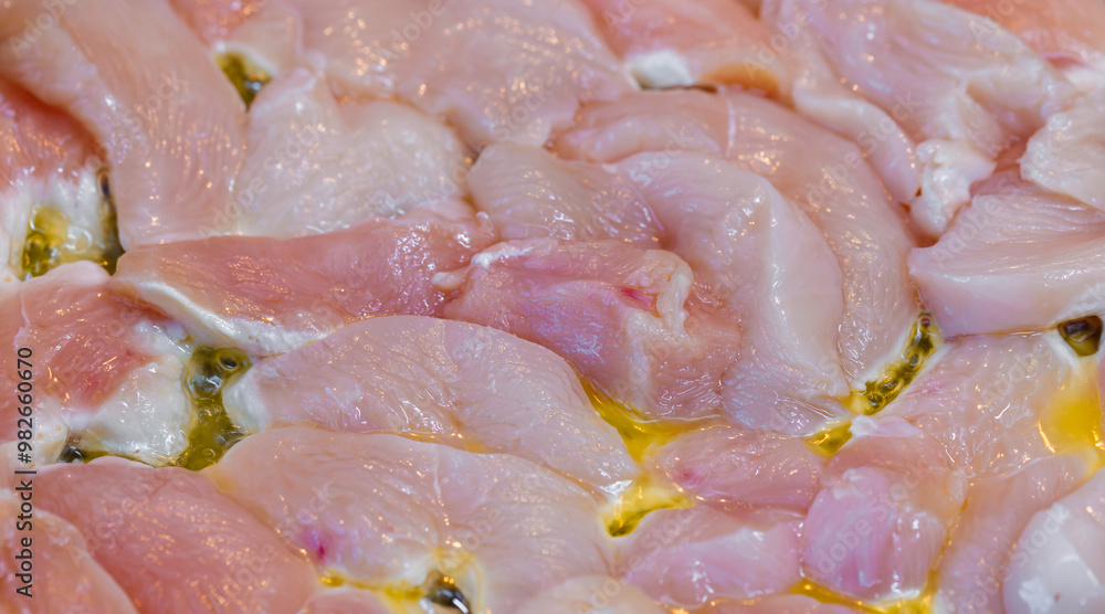 closeup full-frame background of raw chicken breast meat just starting to roast. closeup full-frame background of raw chicken breast meat just starting to roast.