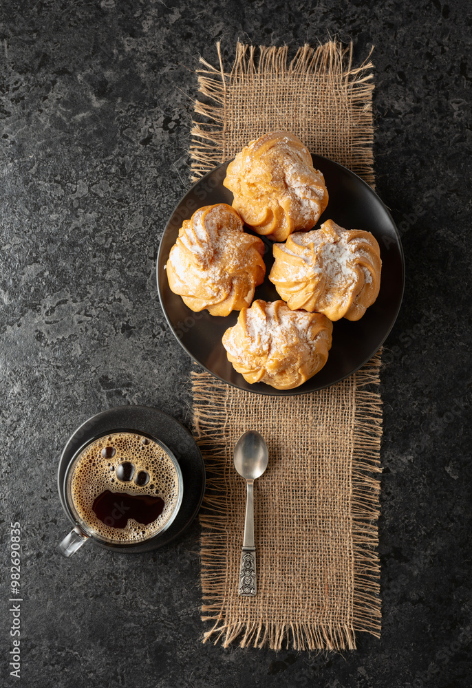 Cream cakes and black coffee on a black table. Cream cakes and black coffee on a black table.