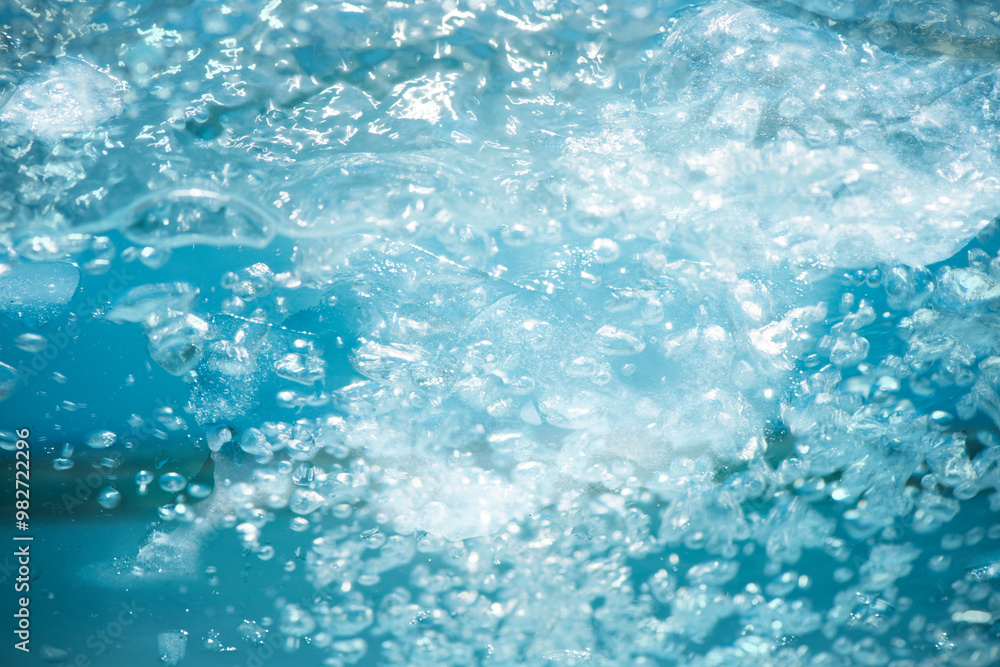 Blue water with ripples on the surface. Defocus blurred transparent blue colored clear calm water surface texture with splashes and bubbles. Water waves with shining pattern texture background. Blue water with ripples on the surface. Defocus blurred transparent blue colored clear calm water surface texture with splashes and bubbles. Water waves with shining pattern texture background.