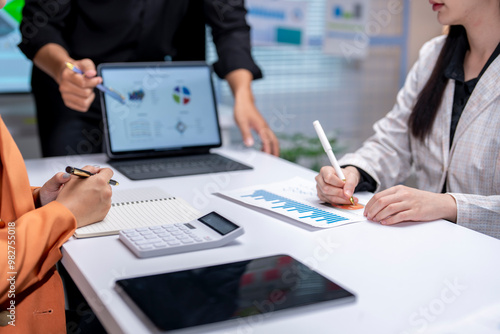 Business people reviewing financial reports and working on their laptops during a meeting