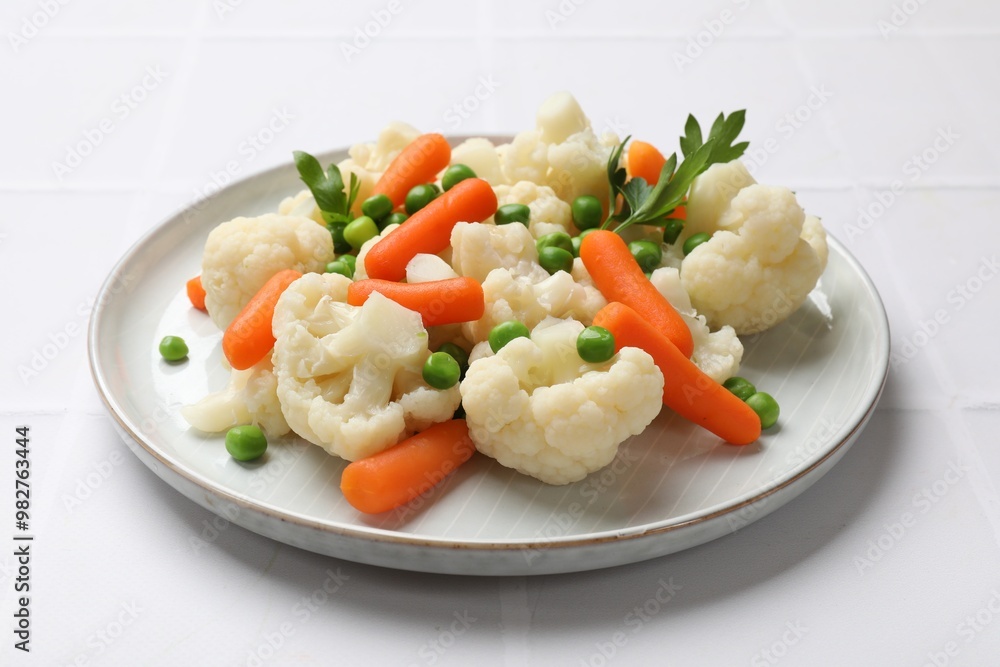 Tasty cauliflower with baby carrots and green peas on white table, closeup