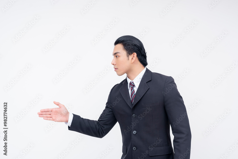 Side view of a serious young asian businessman offering a handshake after a dispute. Being professional and accepting a truce. Isolated on a white background. Side view of a serious young asian businessman offering a handshake after a dispute. Being professional and accepting a truce. Isolated on a white background.