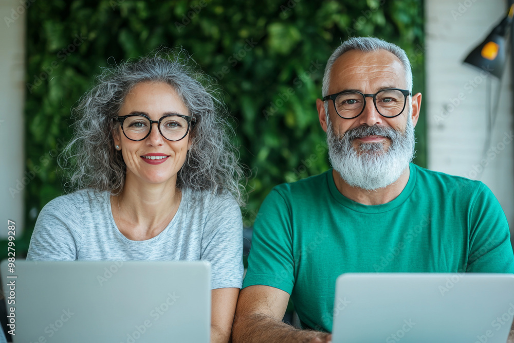 Smiling couple working on laptops Smiling couple working on laptops