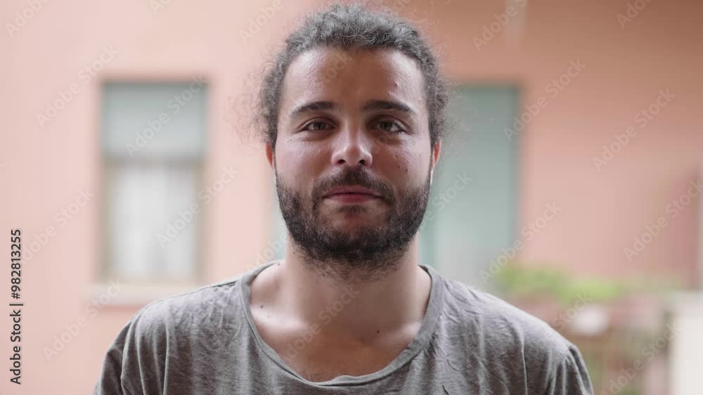 A young man gives a clever and engaging look directly at the camera. Captures a thoughtful and intriguing expression A young man gives a clever and engaging look directly at the camera. Captures a thoughtful and intriguing expression