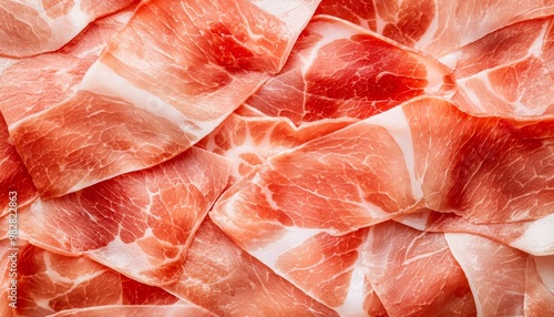 A culinary close-up of perfectly cured prosciutto slices, arranged like a mosaic to emphasize their texture and color.