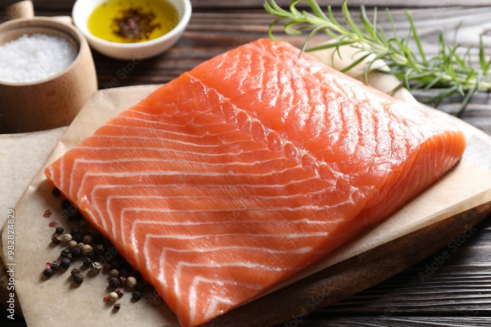 Piece of fresh salmon and spices on wooden table, closeup Piece of fresh salmon and spices on wooden table, closeup