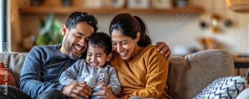 banner happy Latino parents and child spending family time on a cozy sofa in the living room. Family weekend bonding at home with space for your message.