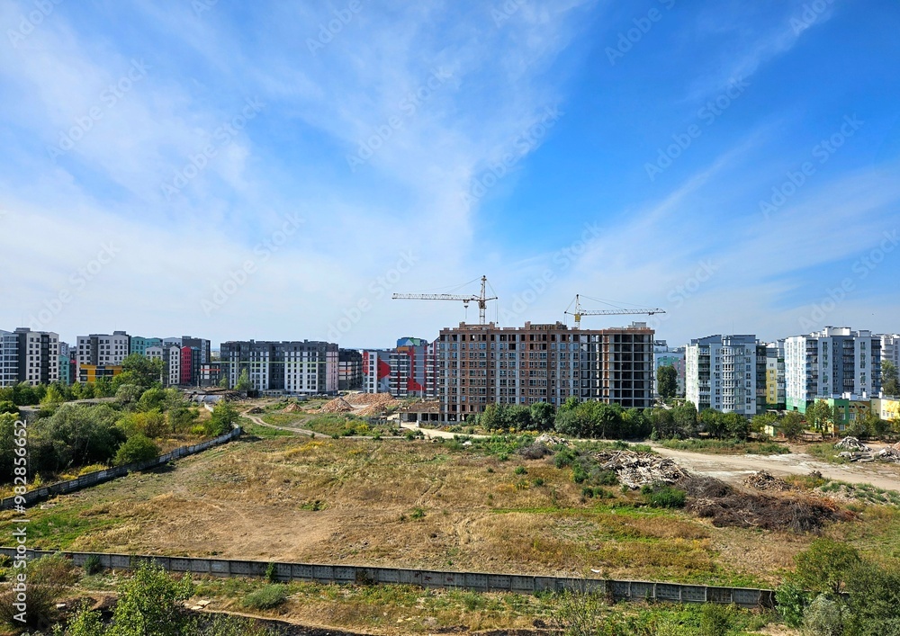 construction site with crane and building, unfinished building. Construction of a residential high-rise building with apartments and parking. Cranes on pouring concrete in formwork. construction site with crane and building, unfinished building. Construction of a residential high-rise building with apartments and parking. Cranes on pouring concrete in formwork.
