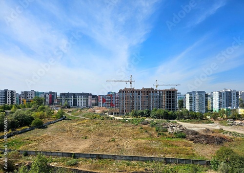 construction site with crane and building, unfinished building. Construction of a residential high-rise building with apartments and parking. Cranes on pouring concrete in formwork.