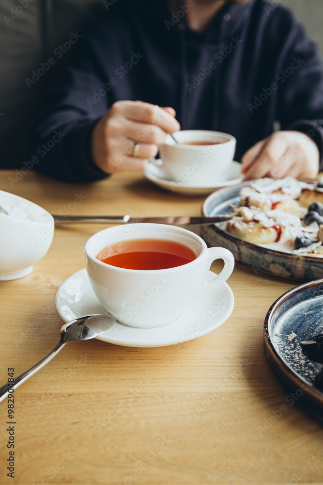 A man drinks tea in a cafe during breakfast, the concept of a sweet breakfast. A man drinks tea in a cafe during breakfast, the concept of a sweet breakfast.