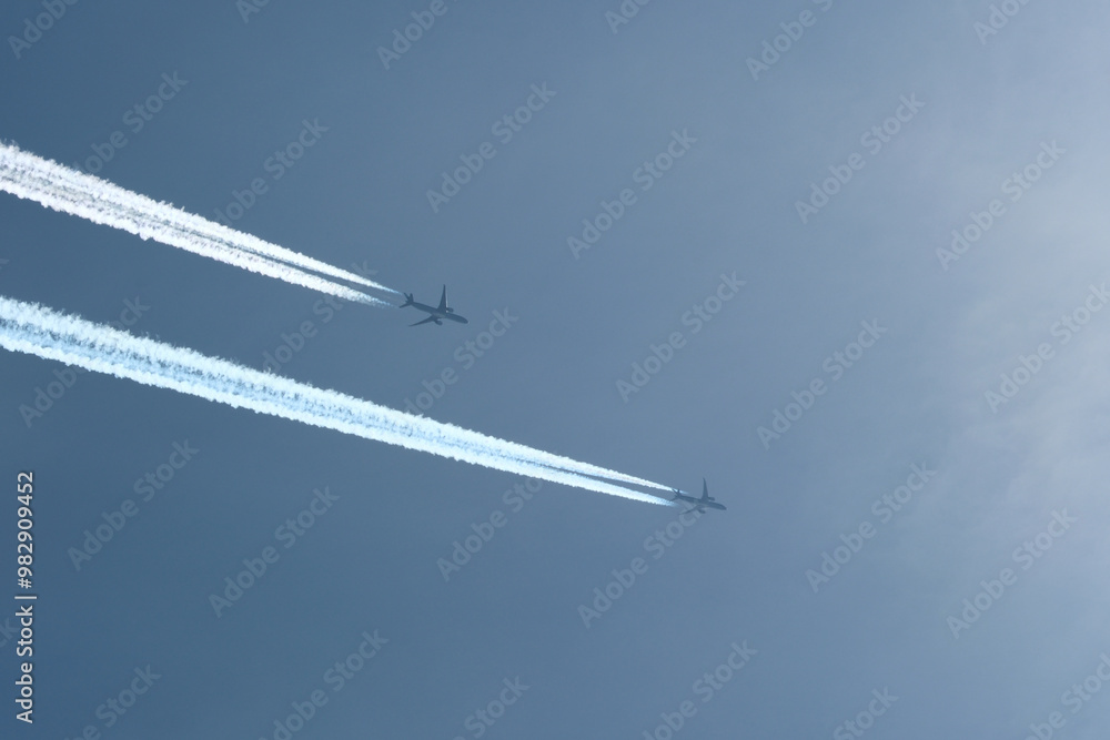 Two planes are flying towards the sun. Airplanes in the blue sky. Airplane with contrail. Two planes are flying towards the sun. Airplanes in the blue sky. Airplane with contrail.