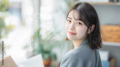 A woman with short hair, dressed casually, happily smiling indoors, portraying a modern and content lifestyle