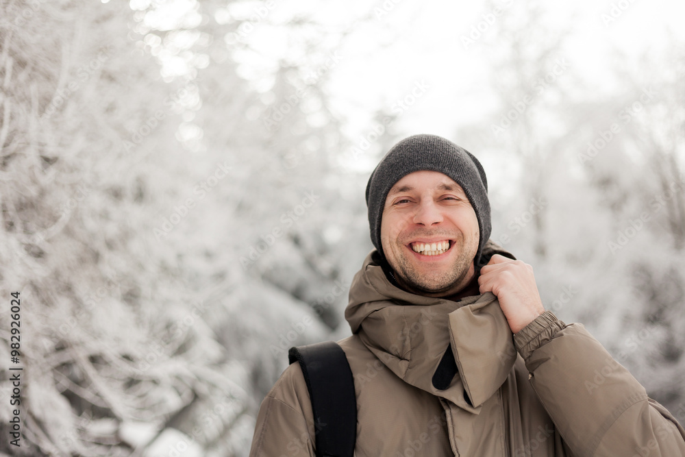 Portrait of young man in warm clothes in winter forest. Hiking. Tourism. Portrait of young man in warm clothes in winter forest. Hiking. Tourism.