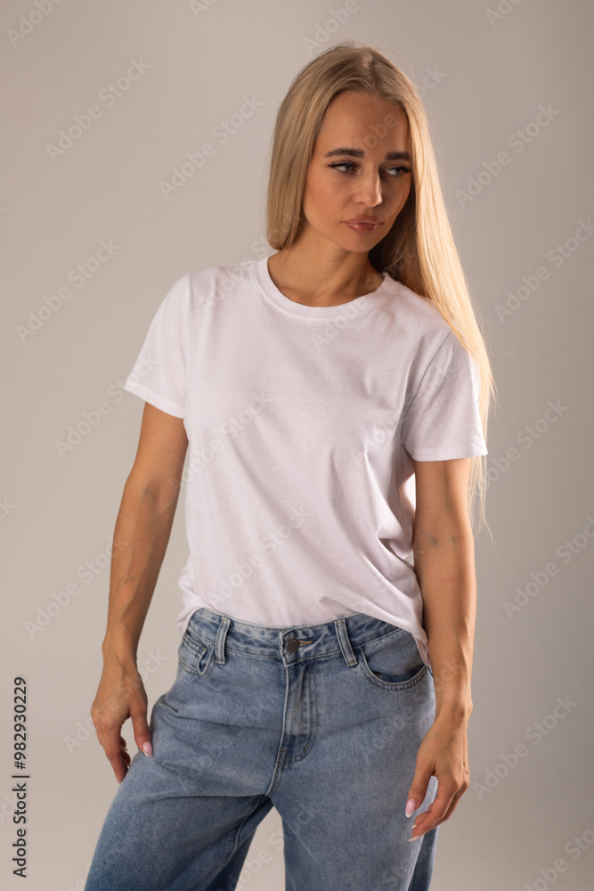 Blonde girl in white t-shirt and jeans posing on white background Blonde girl in white t-shirt and jeans posing on white background