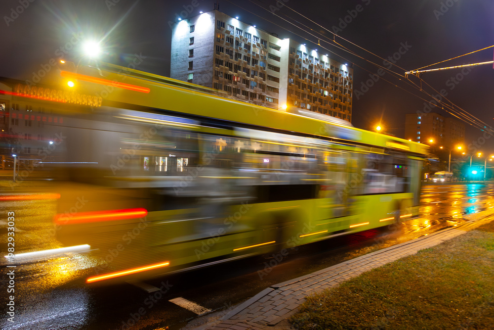 A blurred bus moves along the avenue in the evening. Shot with a long exposure. A blurred bus moves along the avenue in the evening. Shot with a long exposure.