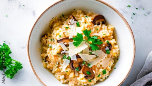 A dish with creamy risotto with fried mushrooms and parmesan cheese, sprinkled with chopped parsley. photo