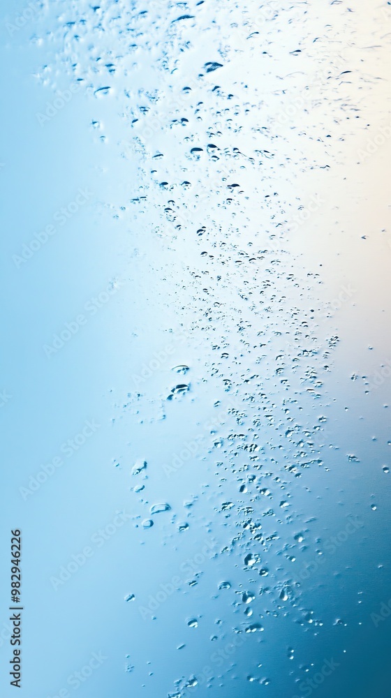 Close-up of water droplets on a blue glass surface, creating a soothing and tranquil atmosphere with a soft gradient background. Close-up of water droplets on a blue glass surface, creating a soothing and tranquil atmosphere with a soft gradient background.