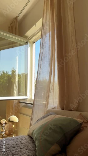 Curtain blowing in the wind by open window