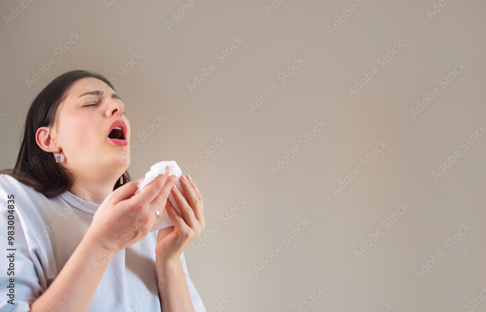 Woman sneezing while covering her nose with a tissue, showcasing an allergic reaction. Woman sneezing while covering her nose with a tissue, showcasing an allergic reaction.