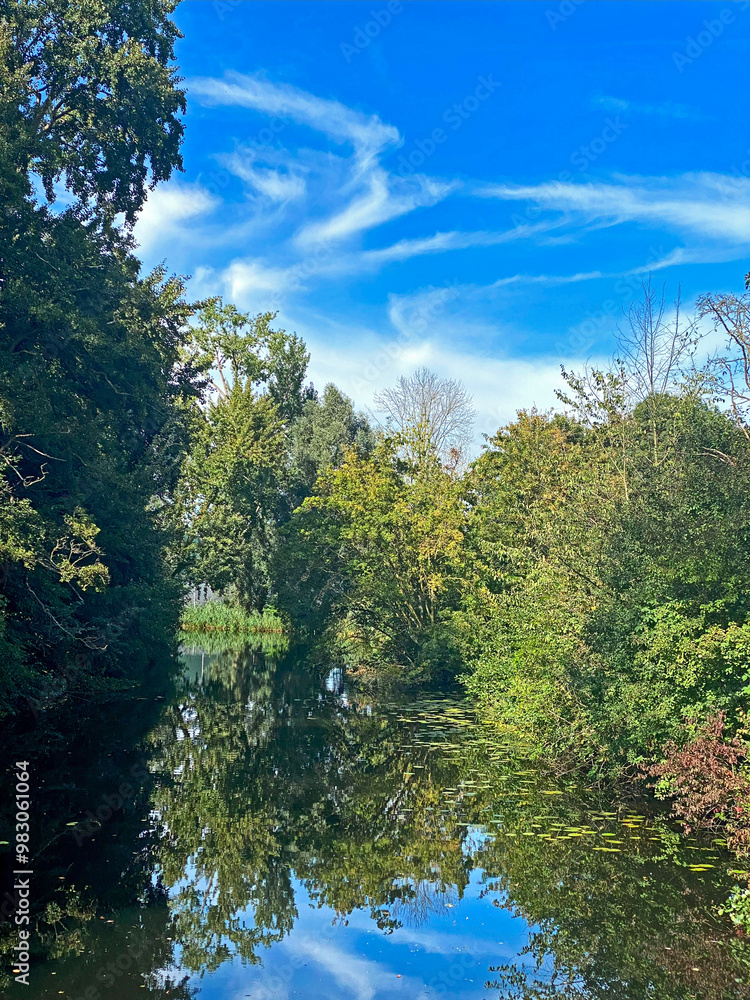 Autumn landscape with blue sky and trees reflected in the water Autumn landscape with blue sky and trees reflected in the water