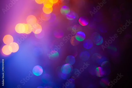 Brilliant gradient circles on a blue texture. Abstract blurred photo of light and bokeh. Festive background. Sparkling glittering backdrop for design. 