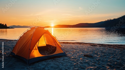 A serene sunset view depicting a vibrant orange tent on a sandy beach beside a tranquil lake, perfect for camping enthusiasts.