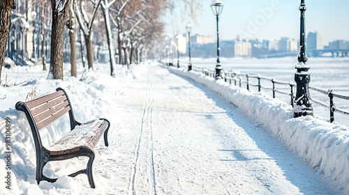 Snowy river trail with an empty bench and lampposts