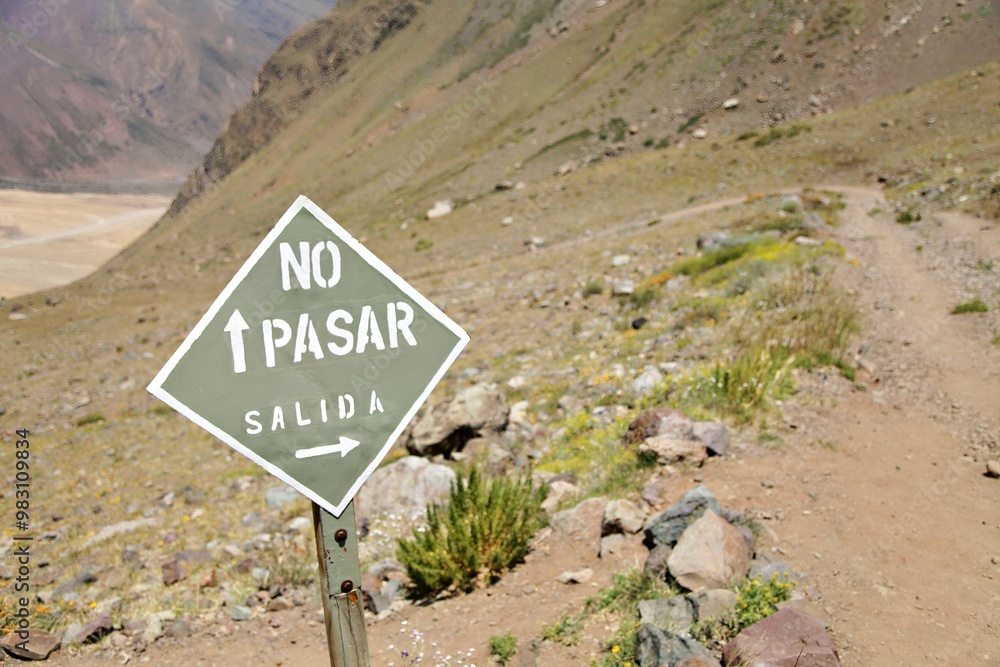 A warning sign in a mountainous area indicating restricted access and directions. A warning sign in a mountainous area indicating restricted access and directions.