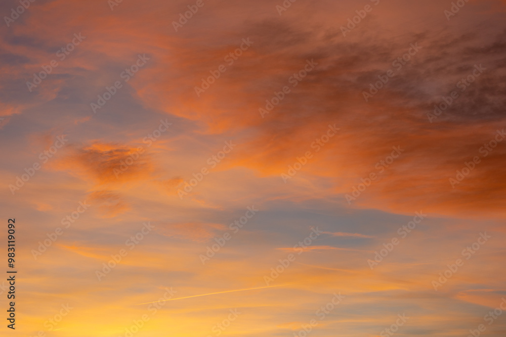 Vivid orange and yellow hues dominate the sky as the sun sets below the horizon, casting long shadows and creating a warm, inviting atmosphere Vivid orange and yellow hues dominate the sky as the sun sets below the horizon, casting long shadows and creating a warm, inviting atmosphere