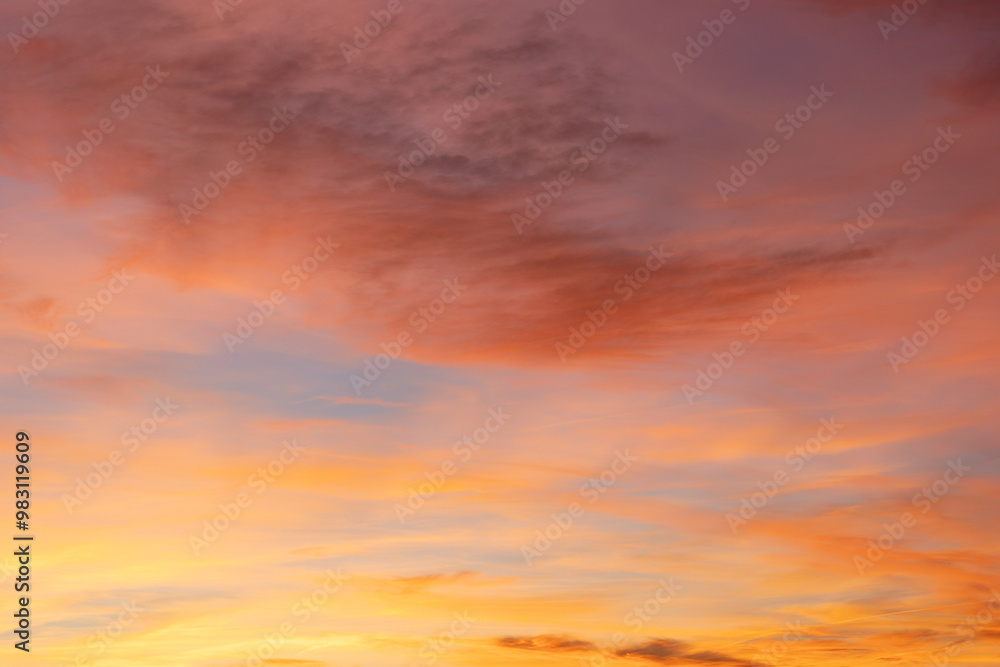 Fototapeta premium Captivating sunset with fiery orange, warm pink, and soft purple hues, as wispy clouds dance across the horizon