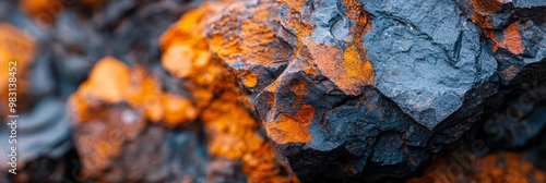  A tight shot of an orange and blue rock formation, with foreground displaying close-up views of these hues Background consists of black rocks photo