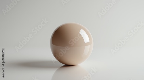 Glossy beige ball reflecting light on a white surface