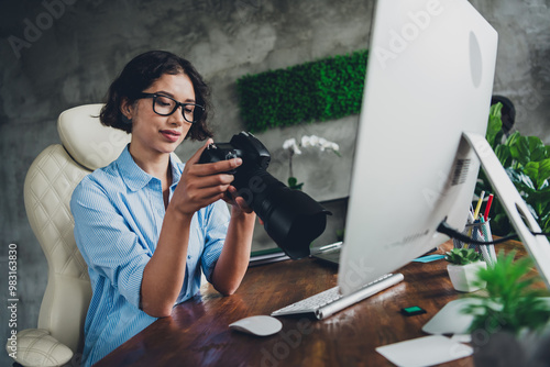 Photo of young woman professional photographer desktop watch camera images loft interior office studio indoors